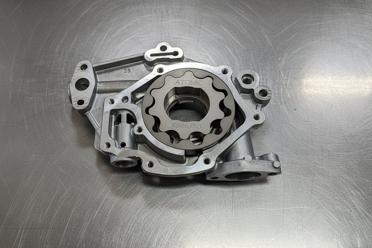 steel oil pump gears in an aluminium oil pump housing with a steel background