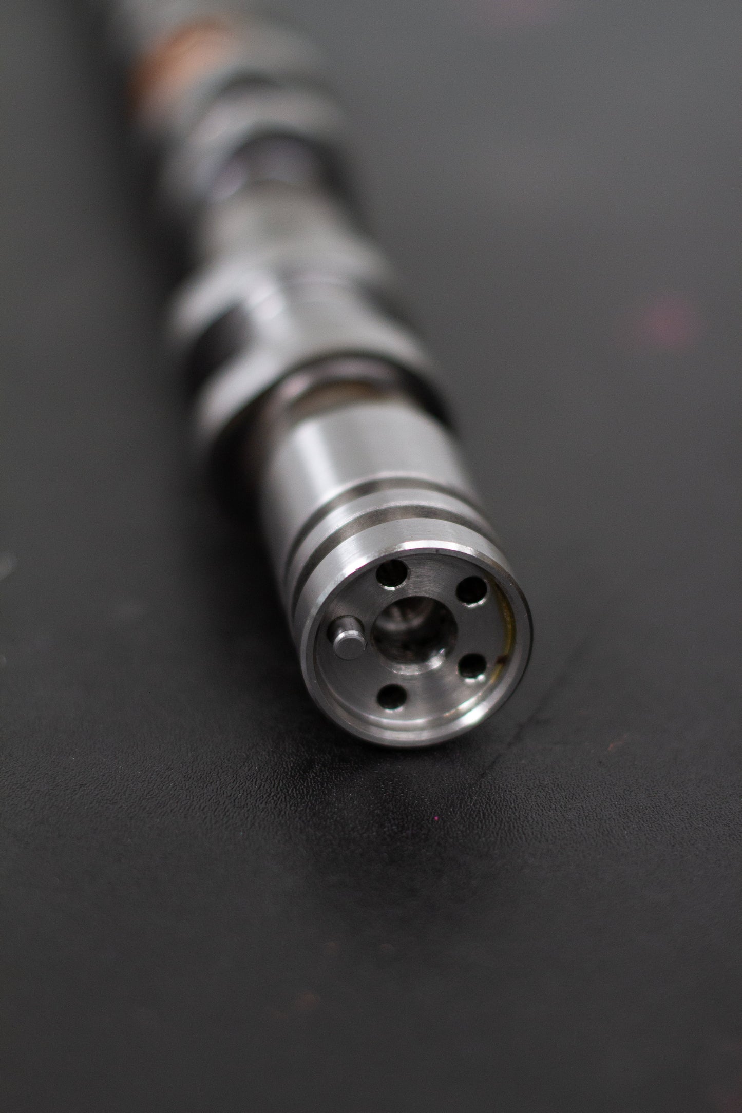 Close-up of a camshaft dowel on a dark background