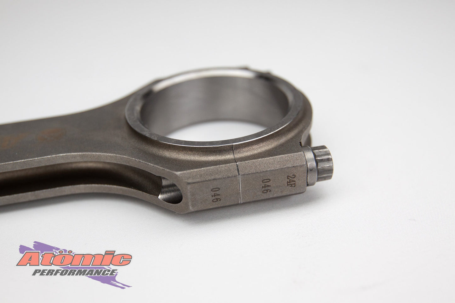 Metal connecting rod with atomic performance products branding on a white background