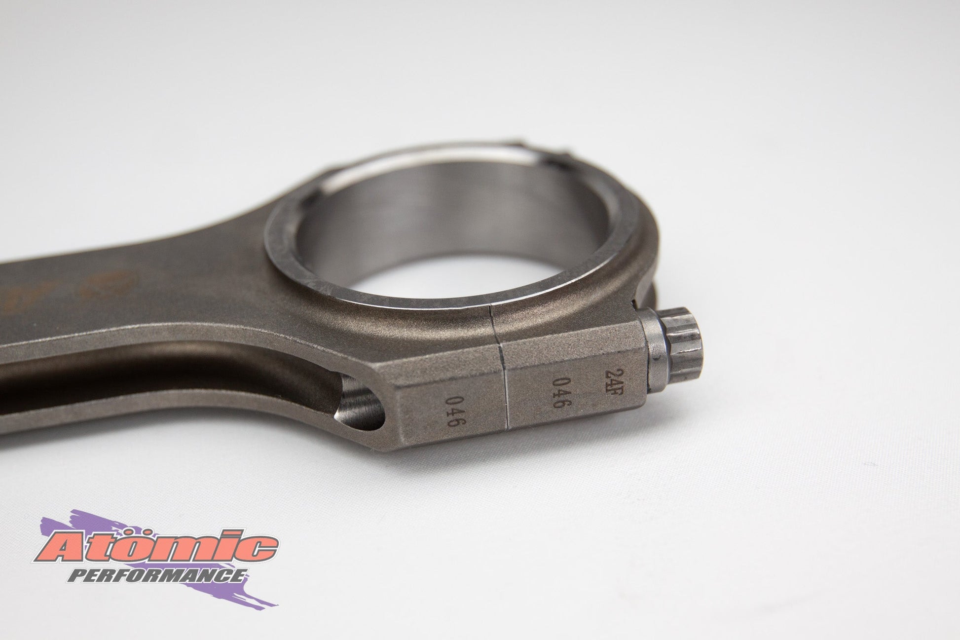 Metal connecting rod with atomic performance products branding on a white background