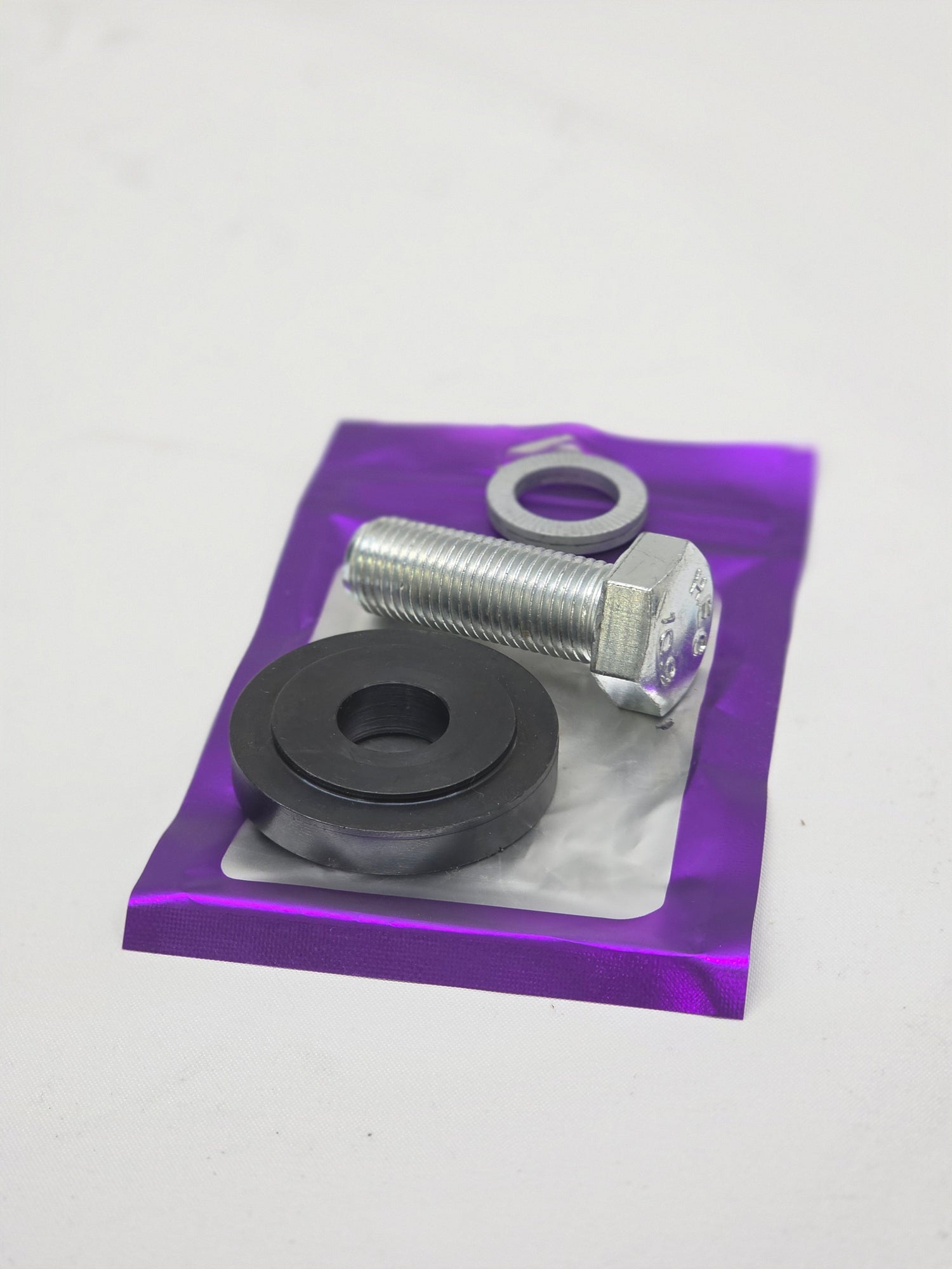 silver bolt with block washer and nordlock washer on purple packaging with white background
