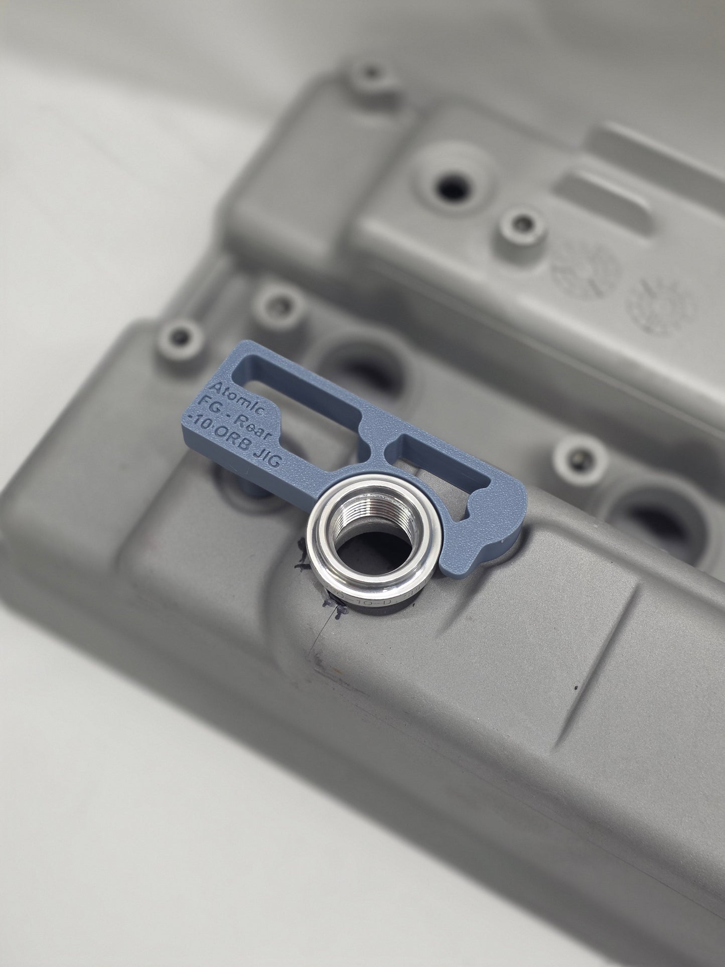 close up of weld on orb with 3d printed fitting jig on engine rocker cover with white background