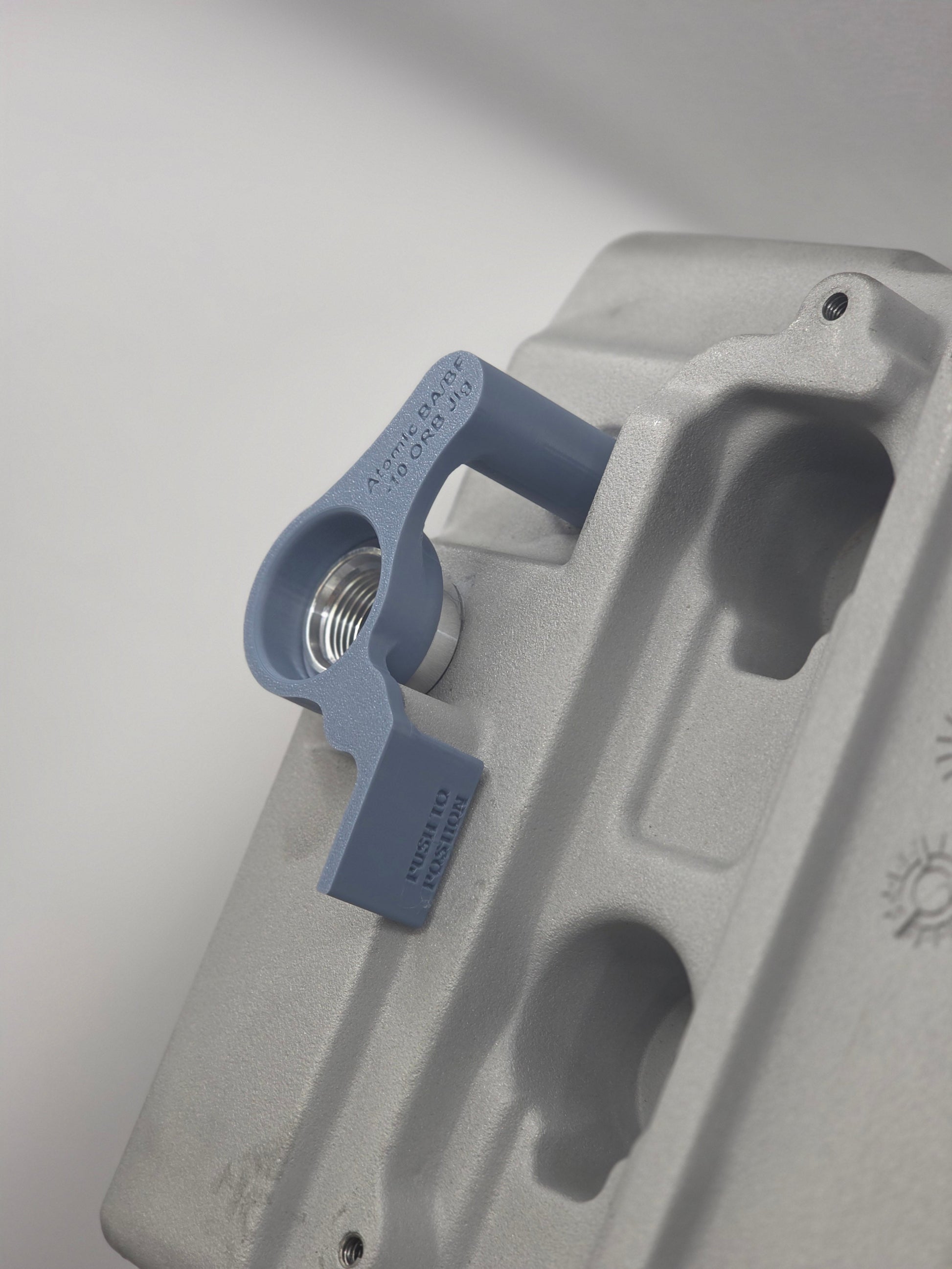 close up of weld on orb with 3d printed fitting jig on engine rocker cover with white background