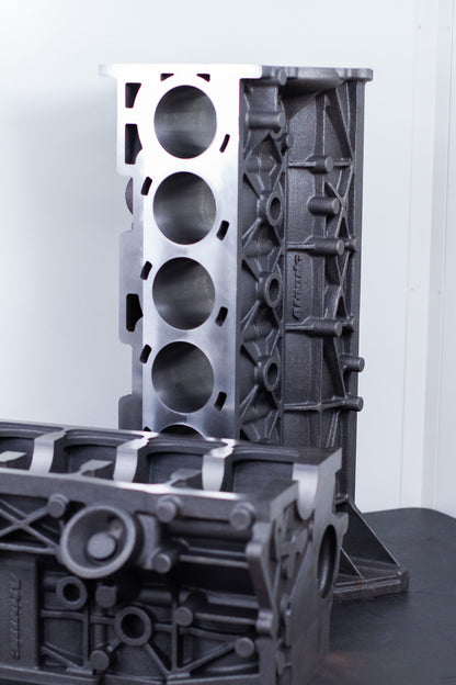 cast engine block on a black surface with a white background