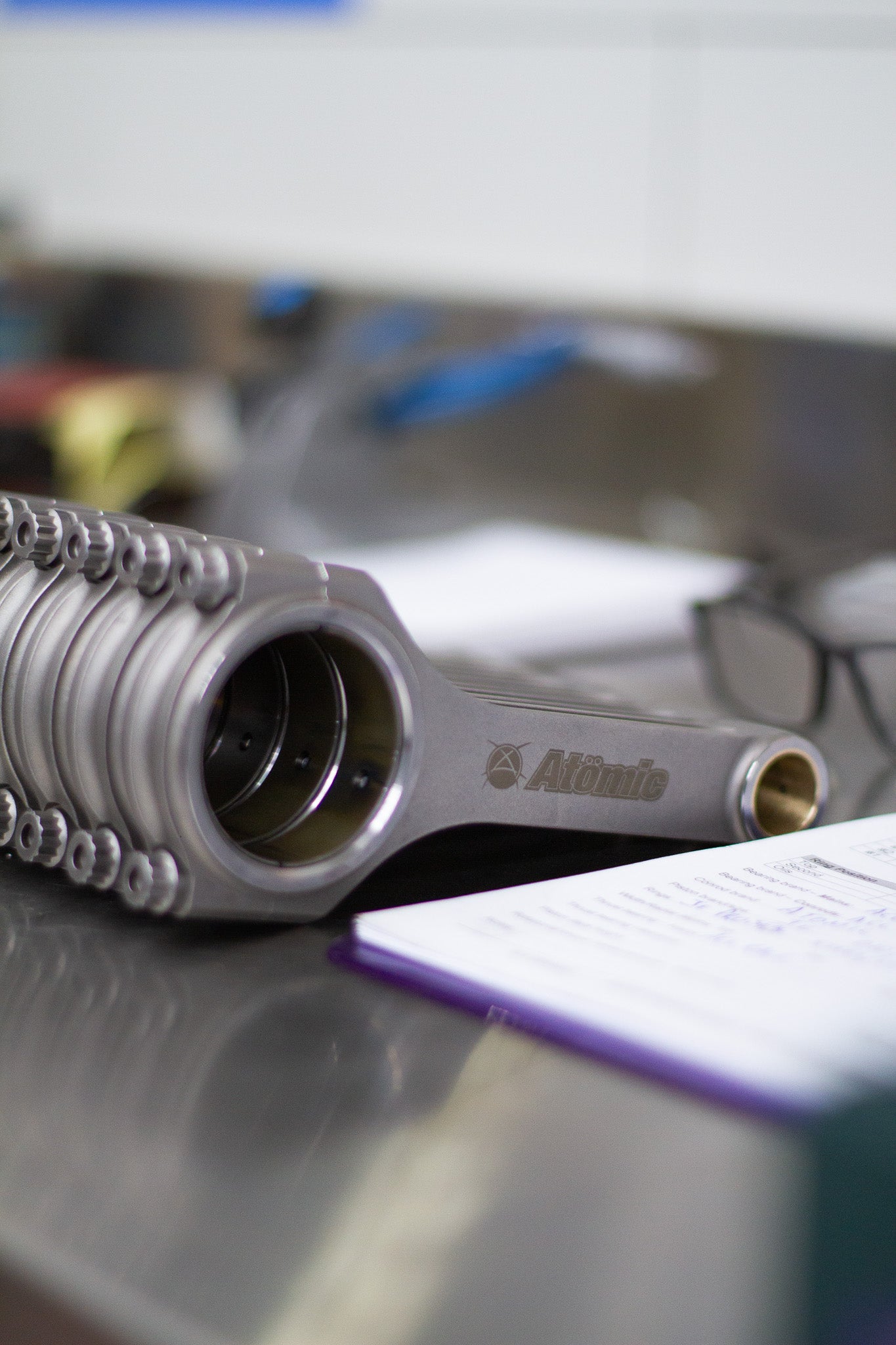 upright engine connecting rods lined up with a workshop setting background