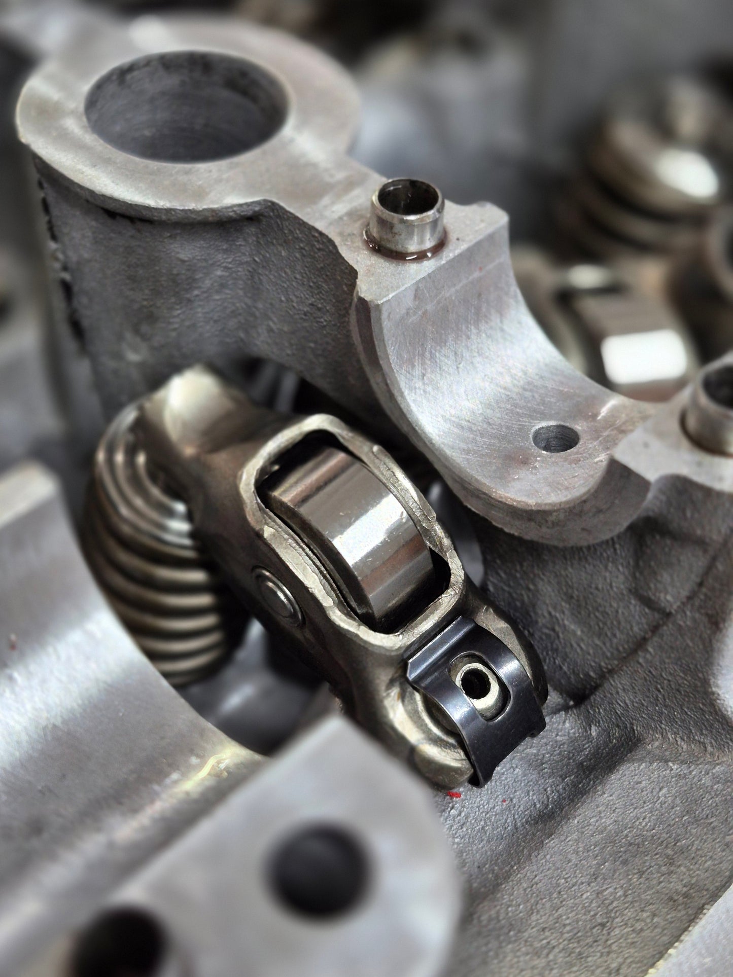 close-up of engine roller rocker and valve spring inside cylinder head 