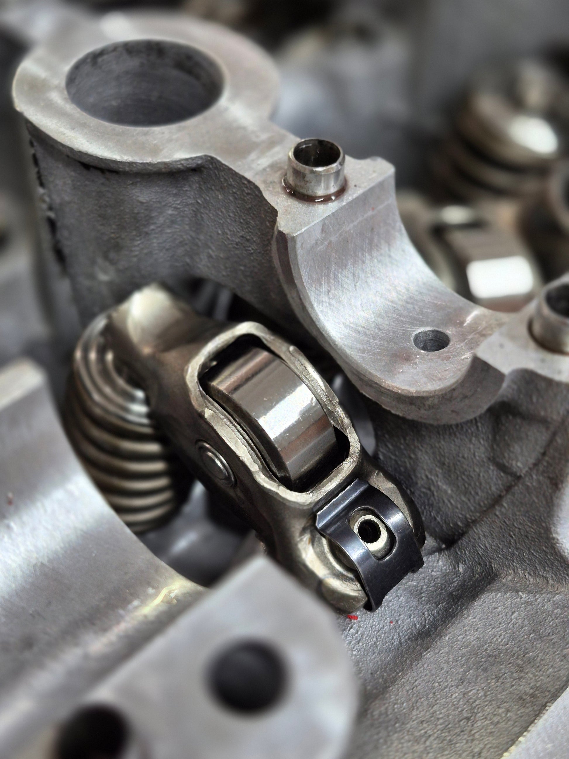 close-up of engine roller rocker and valve spring inside cylinder head 