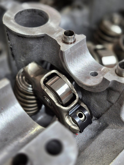 close-up of engine roller rocker and valve spring inside cylinder head 