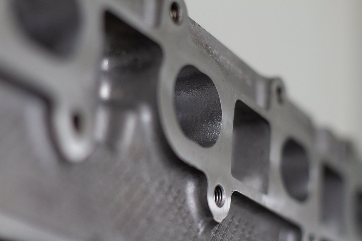 engine cylinder head exhaust port zoomed in with white background