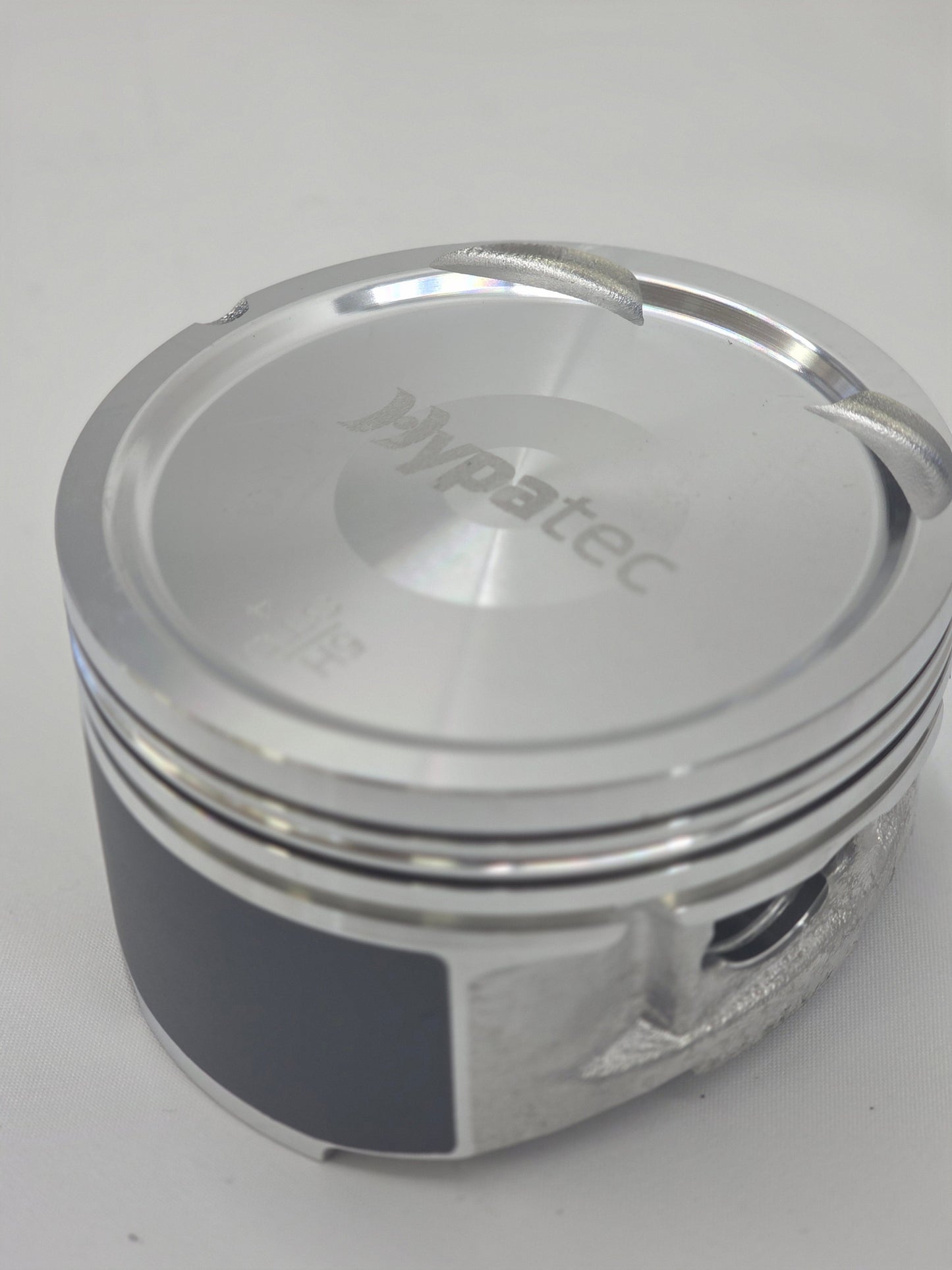 close up of cast engine piston head on white background with engraving 