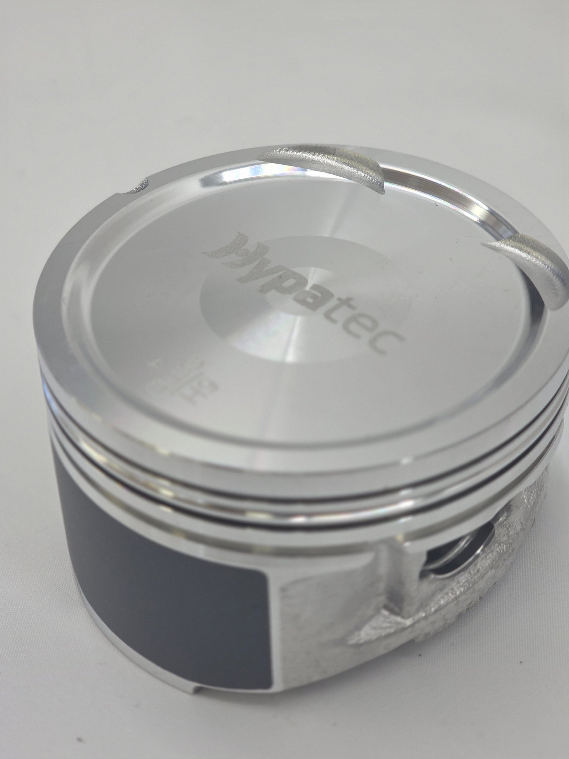 close up of cast engine piston head on white background with engraving 