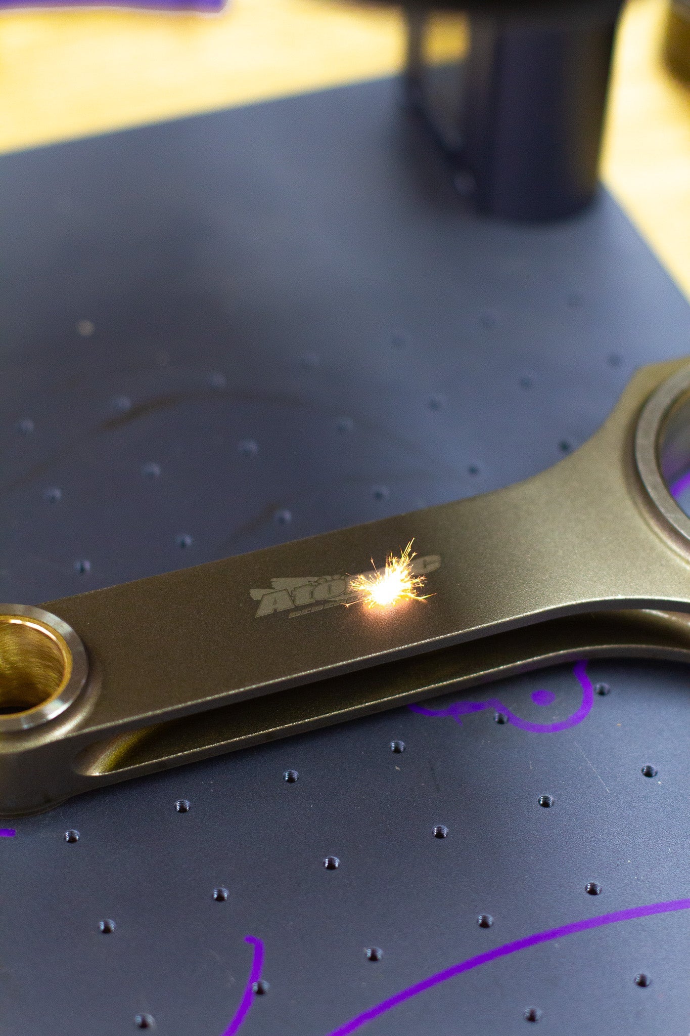 lasering of engine connecting rod with logo with dark background
