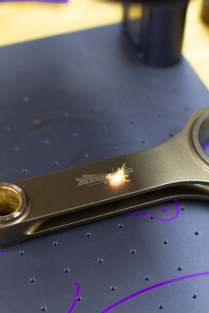 lasering of engine connecting rod with logo with dark background