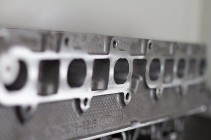 engine cylinder head exhaust port with engine numbers with a white background